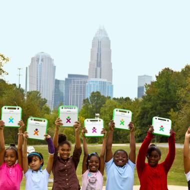 Project LIFT students hold up their laptops